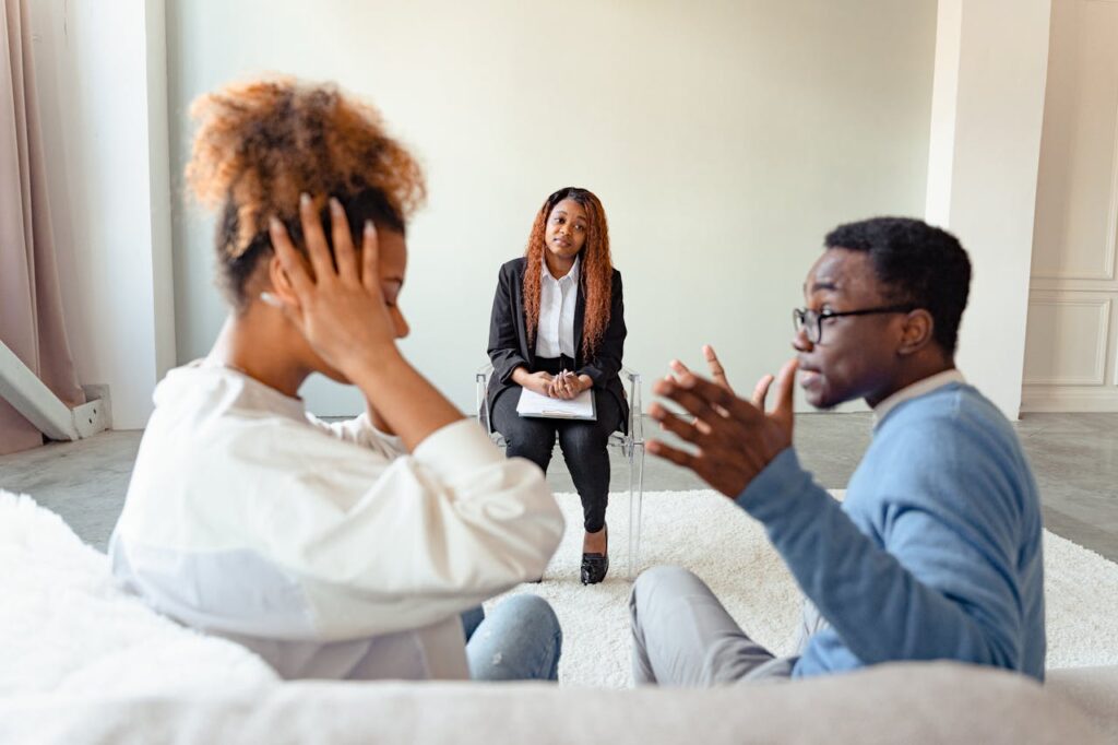 pexels-photo-7579115 A couple in therapy session with a mental health professional indoors.